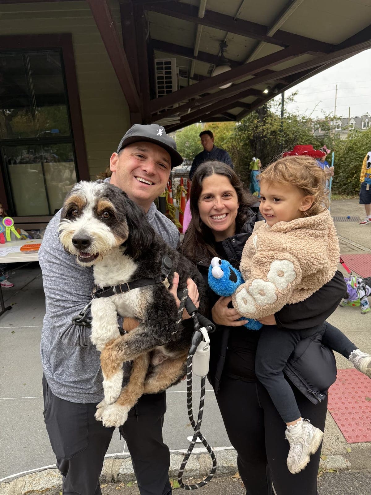 A family and their dog pause near the station building.